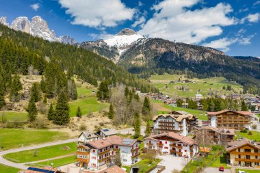 Chalet ile vadi manzarası, İtalya, Trentino, Fontanazzo dağlarının yeşil yamaçları, vadi üzerindeki devasa bulutlar, yerleşim yerlerinin çatıları, yeşil çayırlar, arka plandaki Dolomitler,
