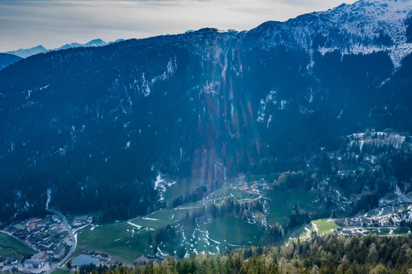 Aerial view of huge valley of the mountains of Italy, Trentino, green meadows, Slopes with green spruce trees, Dolomites on background, The town in the bottom of a valley — Stock Photo, Image