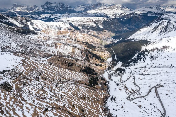 Vue aérienne de la route sinueuse dans les montagnes d'Italie, Dolomites, est serpentine parmi les collines enneigées, est célèbre lieu parmi les skieurs et les fans de comprendre un connu par les voitures de sport, sommet des montagnes — Photo