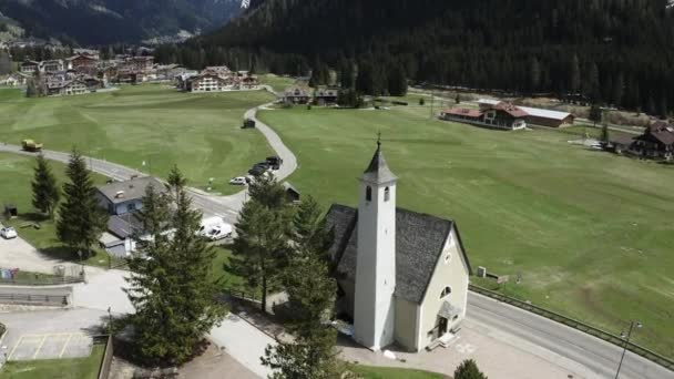 Αεροφωτογραφία της κοιλάδας με την εκκλησία της Παναγίας της Carmel, καταπράσινες πλαγιές των βουνών της Ιταλίας, Trentino, Fontanazzo, πράσινα λιβάδια, Δολομίτες στο παρασκήνιο — Αρχείο Βίντεο