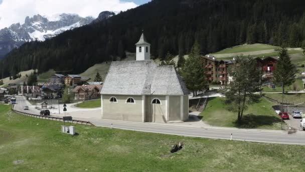 Aerial view of valley with Church of Our Lady of Carmel, green slopes of the mountains of Italy, Trentino, Fontanazzo, green meadows, Dolomites on background — Stock Video