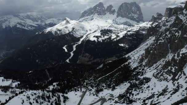 Flygfoto av slingrande väg i bergen i Italien, Dolomiterna, är serpentin bland de snötäckta kullarna, är känd plats bland skidåkare och fans att förstå en känd av sportbilar, berg topp — Stockvideo