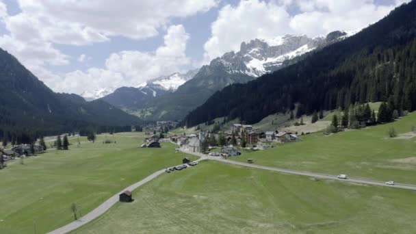 Aerial view of valley with Church of Our Lady of Carmel, green slopes of the mountains of Italy, Trentino, Fontanazzo, green meadows, Dolomites on background — Stock Video