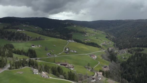 Letecký pohled na nepravděpodobné zelené louky italských Alp, zelené svahy hor, Bolzano, obrovské mraky nad údolím, střechy domů, Dolomity na pozadí, slunce svítí mraky — Stock video