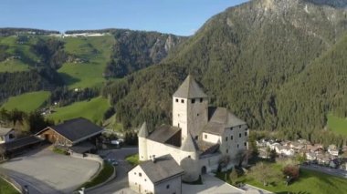 Gün batımında kilisesi olan vadi manzarası, İtalya, Trentino, Güney Tyrol dağlarının yeşil yamaçları, yeşil çayırlar, arka planda Dolomitler, insansız hava aracı uçuşları.