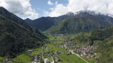Molveno, İtalya 'nın Olasılıkdışı hava manzarası, göl mavisi suyu, boş kumsal, arka planda karla kaplı dağlar Dolomitler, dağ evinin çatısı, güneşli hava, rıhtım,,