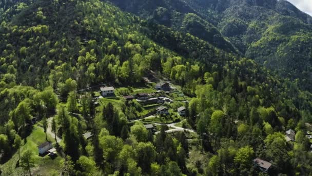 Le paysage aérien improbable du village, Molveno, Italie, eau azur du lac, Dolomites en arrière-plan, Maisons et villas sur une pente de la montagne, épinette par temps ensoleillé, drone vole autour — Video