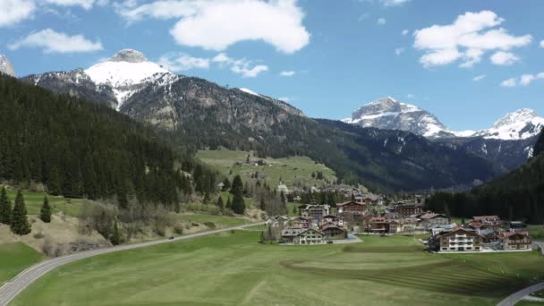 Vue aérienne de la vallée avec village, versants verts des montagnes d'Italie, Trentin, Fontanazzo, nuages énormes sur une vallée, toits de maisons de colonies, prairies verdoyantes, Dolomites en arrière-plan — Video