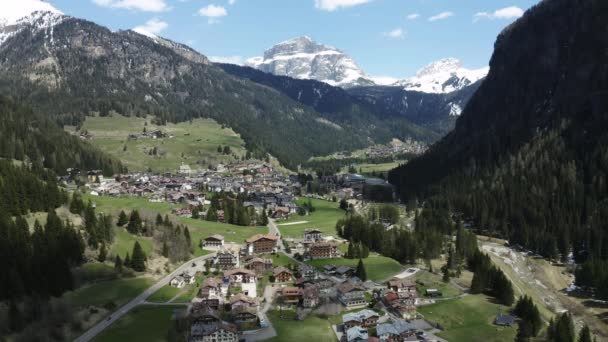 Letecký pohled na údolí s vesnicí, zelené svahy pohoří Itálie, Trentino, Fontanazzo, obrovské mraky nad údolím, střechy domů osad, zelené louky, Dolomity na pozadí — Stock video