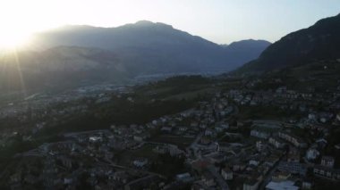 İtalya, Trento, 01 Mayıs 2019: Günbatımında şehrin panoraması, binaların cephesi, akşam dumanından dağların manzarası