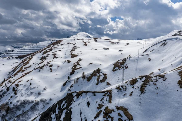 Vista aérea de la carretera torcida en una montaña de Italia, Dolomitas, es serpentina entre las colinas cubiertas de nieve, es famoso lugar entre los esquiadores y aficionados a entender un conocido por los coches deportivos, pico de las montañas — Foto de Stock