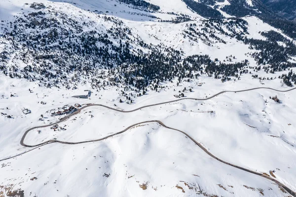Veduta aerea di strada tortuosa in una montagna d'Italia, Dolomiti, è serpentina tra le colline innevate, è famoso luogo tra gli sciatori e gli appassionati di capire un noto da auto sportive, vetta montagne — Foto Stock