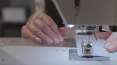 Usta terzinin yakın çekim videosu ve otomatik dikiş makinesinin iğnesi, iyi manikür, kamera hareket etmeden, kareyi dondur. 