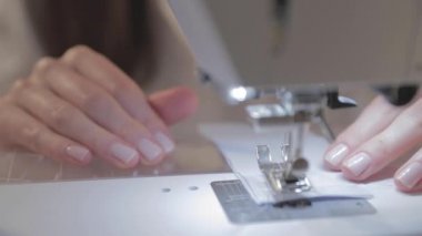 Usta terzinin yakın çekim videosu ve otomatik dikiş makinesinin iğnesi, iyi manikür, kamera hareket etmeden, kareyi dondur. 