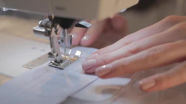 Close-up vídeo em câmera lenta de trabalho da costureira mestre e agulha da máquina de costura automática, boa manicure, câmera se move — Vídeo de Stock