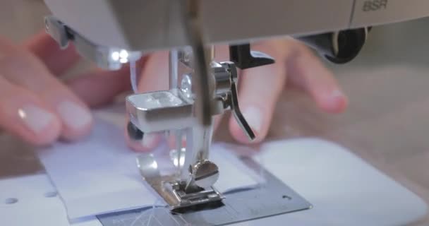 Primer plano video en cámara lenta del trabajo de la costurera maestra y la aguja de la máquina de coser automática, buena manicura, cámara se mueve alrededor — Vídeo de stock