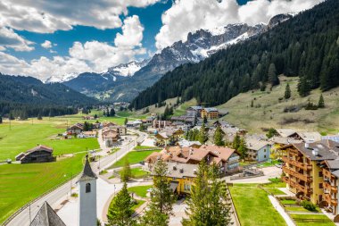 Chalet ile vadi manzarası, İtalya, Trentino, Fontanazzo dağlarının yeşil yamaçları, vadi üzerindeki devasa bulutlar, yerleşim yerlerinin çatıları, yeşil çayırlar, arka plandaki Dolomitler,
