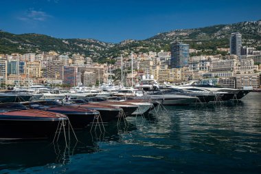 Monaco, Monte-Carlo, 06 Ağustos 2018: Herkül Limanı 'ndaki sükunet, park halindeki tekneler, güneşli bir gün, bir sürü yat ve tekne, bir sürü Rivas teknesi, megayachtlar, pahalı gayrimenkul yığınları.