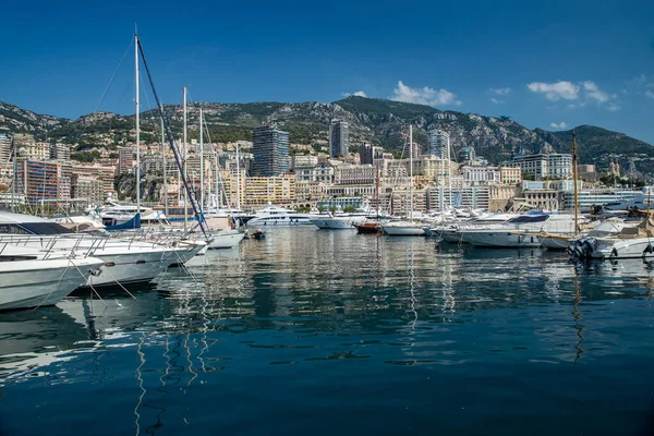 Mônaco, Monte-Carlo, 06 de agosto de 2018: Tranquilidade no porto de Hércules, são os barcos estacionados, dia ensolarado, muitos iates e barcos, muitos barcos Rivas, megayachts, maciço de imóveis caros — Fotografia de Stock