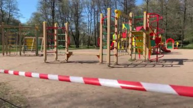 Oyun alanı, dünyada koronavirüs salgını sırasında karantina sırasında parkta kırmızı ve beyaz bir kurdele ile çevrili. Bölgede hiç çocuk yok, giriş kapalı.