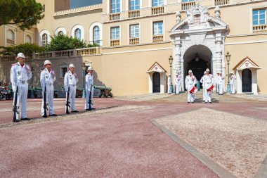 Monaco, Old Town, 27 Eylül 2019: Prenslerin sarayının muhafızlarının şenlikli değişimi, beyaz bir üniforma, çok sayıda silah, kraliyet kalesi cephesi, sarayın önündeki meydan, güneşli bir gün.