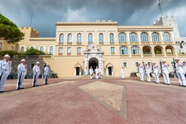 Monaco, Old Town, 27 Eylül 2019: Prenslerin sarayının muhafızlarının şenlikli değişimi, beyaz bir üniforma, çok sayıda silah, kraliyet kalesi cephesi, sarayın önündeki meydan, güneşli bir gün.