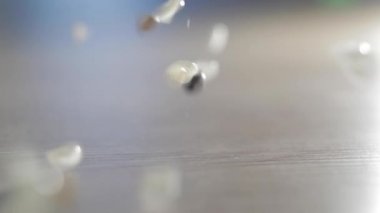 Masanın üzerindeki çeşitli renkli düğmelerin yavaş çekimleri. Plastikten yapılmış farklı renkli düğmeler. Dikiş malzemeleri, giysi aksesuarları, dikiş ipliği, dikiş düğmeleri, tekstil aksesuarları.