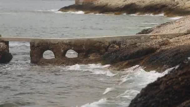 Olas rompen alrededor de la costa rocosa de la costa azul, salpicaduras, agua clara, agua azul, lugar famoso — Vídeo de stock