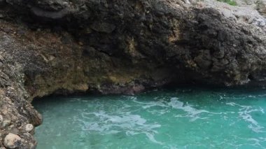 Gök mavisi sahillerin kayalık sahillerinde dalgalar kopuyor, su sıçrıyor, berrak sular, masmavi sular, ünlü bir yer.