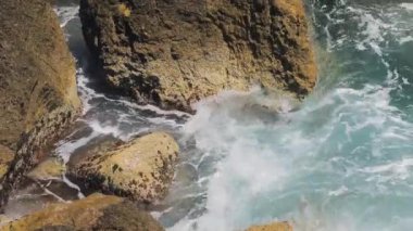 Gök mavisi sahillerin kayalık sahillerinde dalgalar kopuyor, su sıçrıyor, berrak sular, masmavi sular, ünlü bir yer.