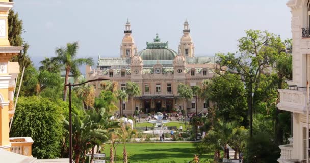 Mónaco, Montecarlo, 02 de octubre de 2019: Casino Monte Carlo, vista principal del casino principado rodeado de árboles verdes, la fachada actualizada, a través de la fuente, día soleado — Vídeos de Stock