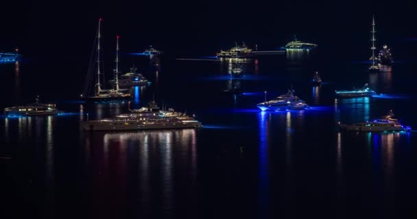 Monaco, Monte-Carlo, lapso de tempo de muitos veleiros e barco a motor, estacionamento na baía, festa em barcos, transportando rapidamente por barcos, iluminação noturna, mastros altos, multi colorido — Vídeo de Stock