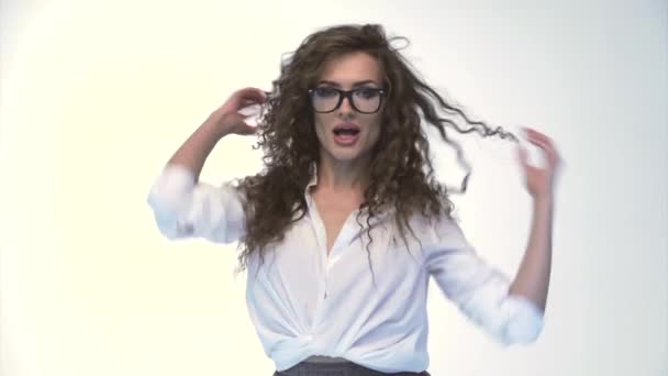 Die junge schöne Frau mit lockigem Haar posiert, zappelt und flirtet vor der Kamera, Nahaufnahme, weißer Hintergrund, tanzt, kokettiert, Verschiedene Emotionen auf einem Gesicht — Stockvideo