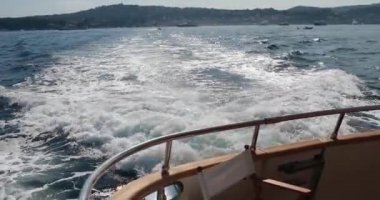 Yattan köpüklü yol yavaş ilerliyor, tekne denizden geçiyor, gün batımında geminin altından yükselen deniz suyu, yüksek hız, lüks yaşam, açık güneşli hava, Ligurian Denizi, hiç kimse