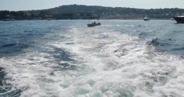 Yattan köpüklü yol yavaş ilerliyor, tekne denizden geçiyor, gün batımında geminin altından yükselen deniz suyu, yüksek hız, lüks yaşam, açık güneşli hava, Ligurian Denizi, hiç kimse