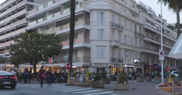 Frankrijk, Cannes, 27 mei 2017: Straten van Cannes in de bioscoop Filmfestival van Cannes, takken palmen bij zonsondergang, dijk, dames en heren in avondjurken, drukke cafés, amusement — Stockvideo