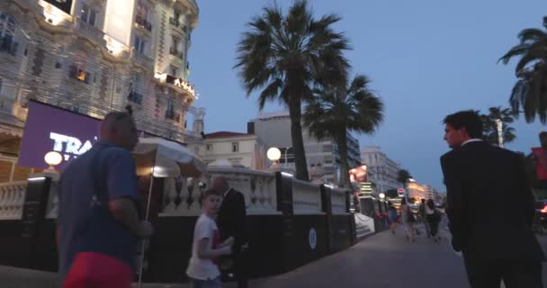 Fransa, Cannes, 27 Mayıs 2017: Cannes sokakları sinemada Cannes Film Festivali, gün batımında palmiye dalları, toprak seti, gece elbiseli bayanlar ve baylar, kalabalık kafeler, eğlence alanları — Stok video