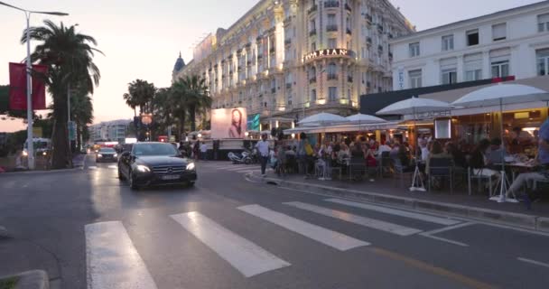 Frankreich, Cannes, 27. Mai 2017: Straßen von Cannes beim Filmfestival in Cannes, Palmenzweige bei Sonnenuntergang, Böschung, Damen und Herren in Abendkleidern, überfüllte Cafés, Unterhaltung — Stockvideo