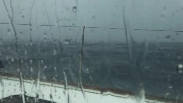 Vista a través de la ventana del barco, tormenta en el mar Adriático cerca de la costa de Croacia, fuerte lluvia fuerte a través de ventanas de catamarán, el cielo tormentoso, gotas en la ventana — Vídeo de stock