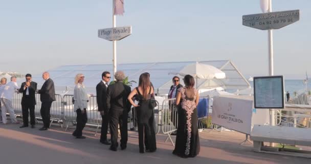 Francia, Cannes, 27 de mayo de 2017: Calles de Cannes durante el Festival de Cannes al atardecer, gente festiva en terraplén, damas y caballeros en vestidos de noche, industria de los espectáculos — Vídeo de stock