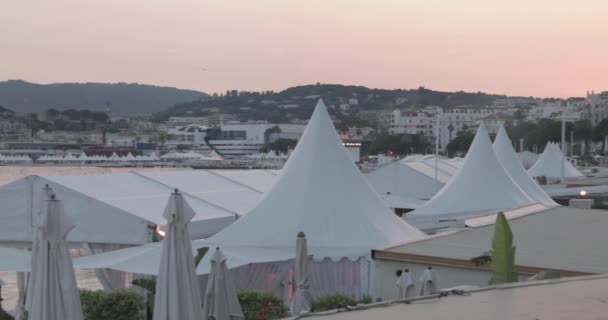 Francie, Cannes, 27. května 2017: Slavnostní nábřeží Cannes během filmového festivalu v Cannes při západu slunce, plážové kavárny, slunečníky, přeplněné kavárny, růžová obloha — Stock video