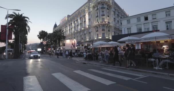 Francie, Cannes, 27. května 2017: Ulice Cannes v kině Cannes Filmový festival, větve palem při západu slunce, nábřeží, dámy a pánové ve večerních šatech, přeplněné kavárny, zábava — Stock video