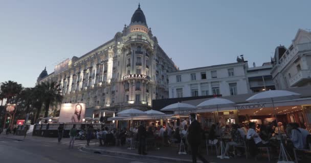 França, Cannes, 27 de maio de 2017: Ruas de Cannes no cinema Festival de Cannes, galhos palmeiras ao pôr do sol, diques, senhoras e senhores vestidos de noite, cafés lotados, entretenimentos — Vídeo de Stock