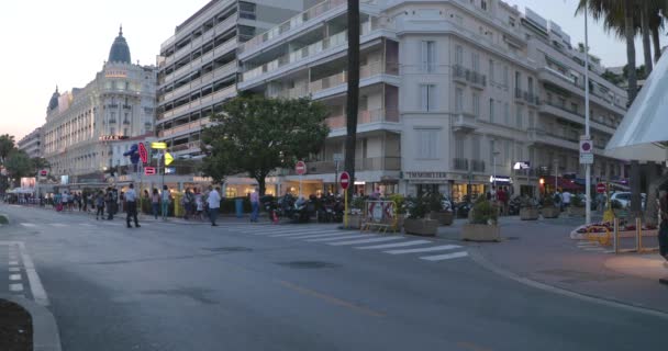 Francia, Cannes, 27 de mayo de 2017: Calles de Cannes en el cine Festival de Cannes, sucursales palmeras al atardecer, terraplén, damas y caballeros en vestidos de noche, cafeterías abarrotadas, entretenimientos — Vídeos de Stock