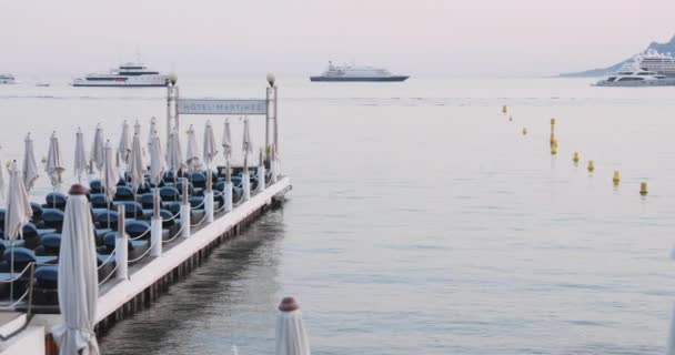 法国，戛纳，2017年5月27日：电影《戛纳电影节》期间的戛纳河堤、海滩咖啡馆、雨伞、拥挤的咖啡馆、粉红的天空 — 图库视频影像
