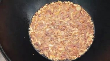 Ulusal Özbek yemeği pilavı, pilav, pilav, pilav, büyük tavada etli pilav. Pişirme işlemi, ateş açın. Kazanda ateşte yemek pişirmek. Hazırlık aşamaları. Karamel ve pilau renginde kızartılmış soğanlar.