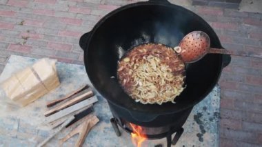 Ulusal Özbek yemeği pilavı, pilav, pilav, pilav, büyük tavada etli pilav. Pişirme işlemi, ateş açın. Kazanda ateşte yemek pişirmek. Hazırlık aşamaları. Karamel ve pilau renginde kızartılmış soğanlar.