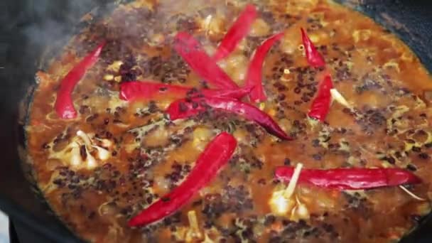 Nationaluzbekisk pilaf, pilaw, plov, ris med kött i stor panna. Koka, tillaga processen i en kittel på eld, röd paprika och hela vitlök — Stockvideo