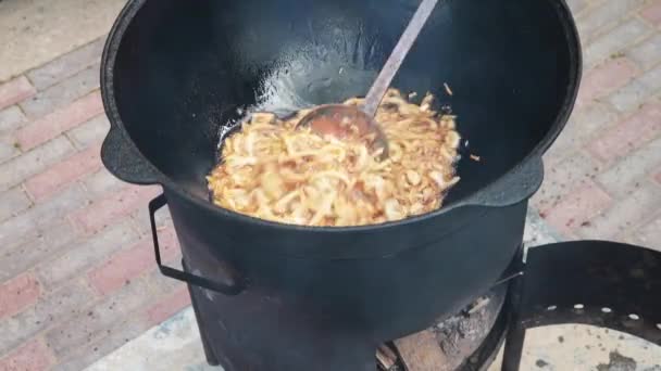 Plato nacional uzbeko pilaf, pilaw, plov, arroz con carne en sartén grande. Proceso de cocción, fuego abierto. Cocinar en un caldero en llamas. Etapas de preparación. La cebolla asando hasta el color del caramelo, pilau — Vídeos de Stock