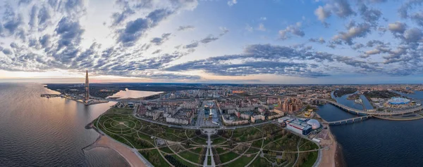 Rusya, St.Petersburg, 06 Mayıs 2020: Avrupa 'nın en yüksek gökdeleninin gün batımında Lakhta şehir merkezindeki havadan panoramik görüntüsü, 300 yıldönümü parkı ve Gazprom stadyumunun gece aydınlatması 